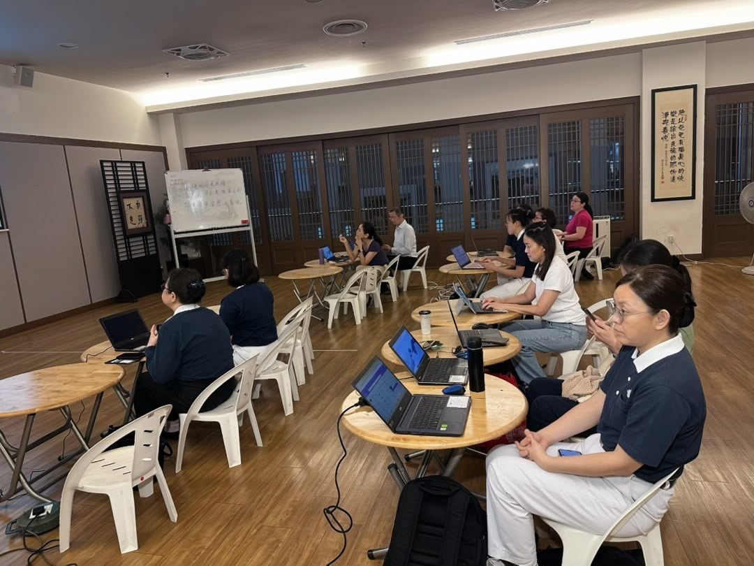 Tzu Chi International Medical Association volunteer doctors and nurses working through MedicalMet clinic software on laptops during hands-on training at Jing Si Hall — MedicalMet